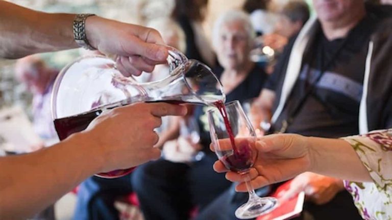 Personnes trinquant au vin rouge