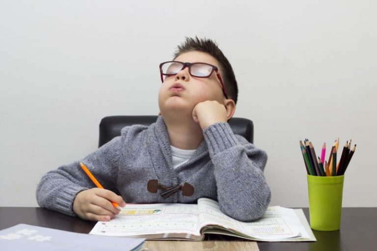 un enfant s’entraîne à bien écrire