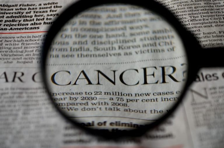 image d'une page de journal avec le mot cancer passé à la loupe