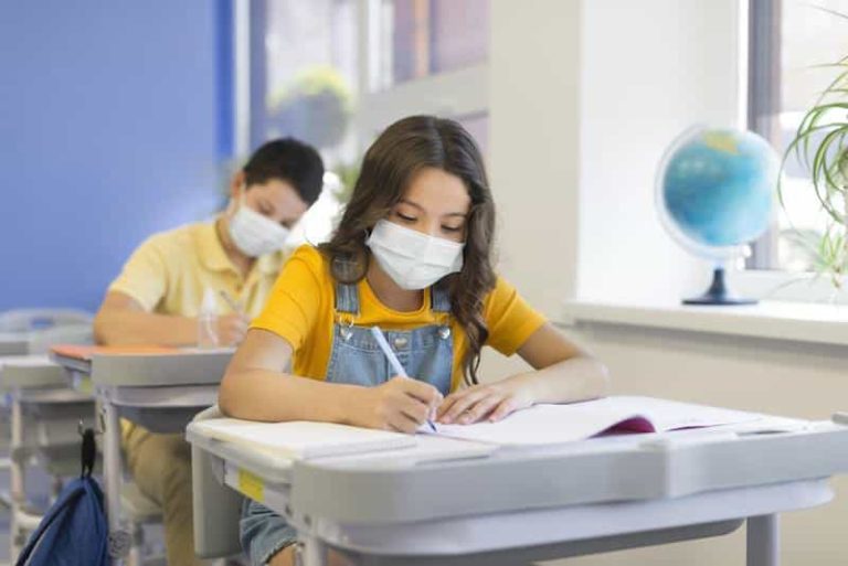 Ecolier portant un masque dans sa classe.