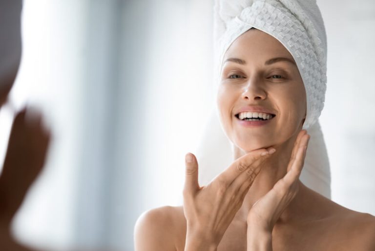 Beauté : une jeune femme se maquille devant son miroir.