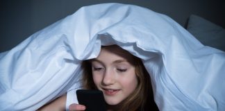 Une collÃ¨gienne consultant son smartphone en cachette durant la nuit.