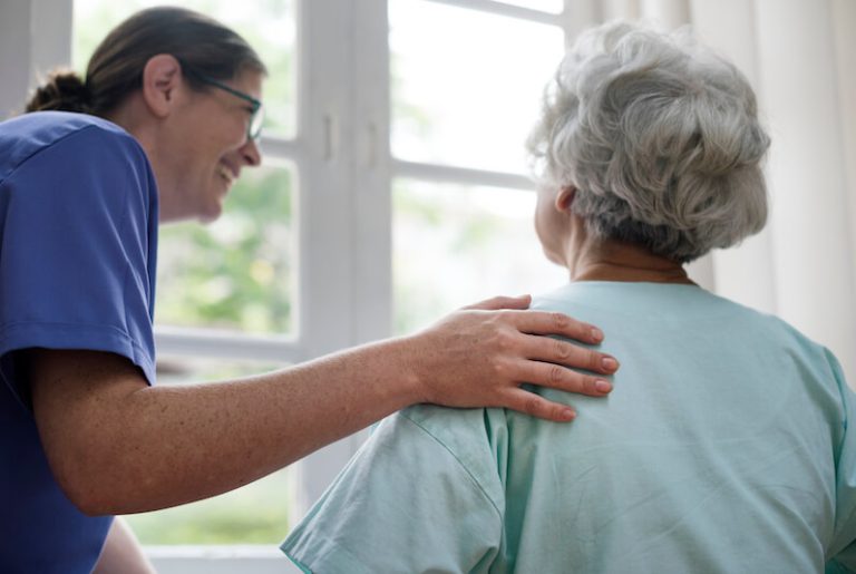 Une aide à domicile s'occupe d'une personne âgée.