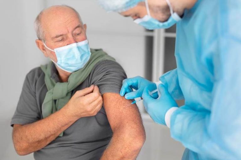Un homme âgé reçoit la double vaccination grippe et covid-19.
