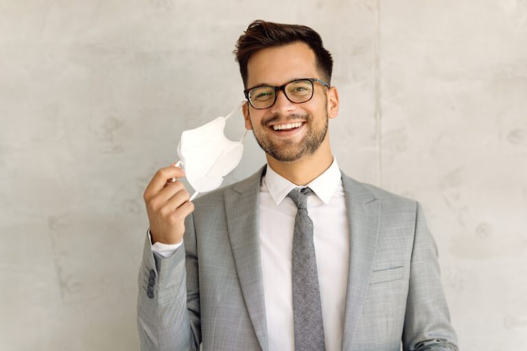 Un jeune homme heureux d'enlever son masque anti Covid-19.