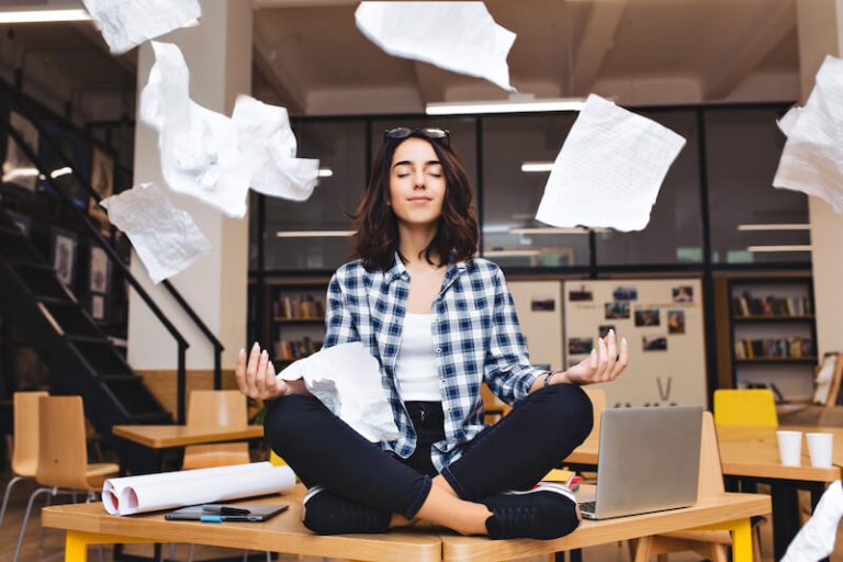 Une femme pratiquant la méditation pour évacuer son stress au travail.