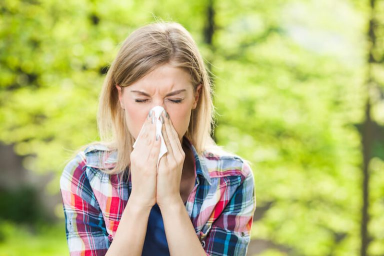Une jeune femme souffrant du retour de ses allergies aux pollens.