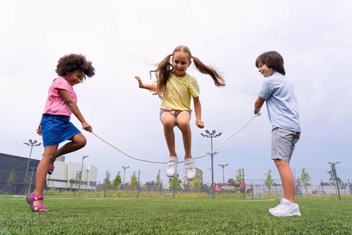 Trois enfants font de la corde à sauter