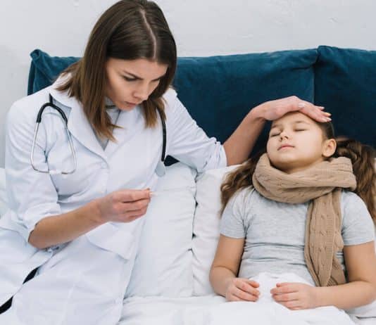 un médecin prend la température d'une jeune enfants.
