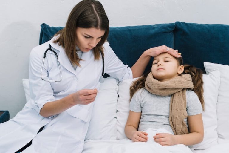un médecin prend la température d'une jeune enfants.