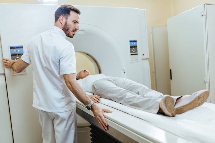 un manipulateur en électroradiologie médicale installe un patient pour faire une IRM.