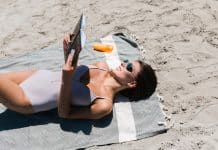 Une femme bronze au soleil sur la plage.