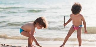 Deux enfants jouent sur la plage.