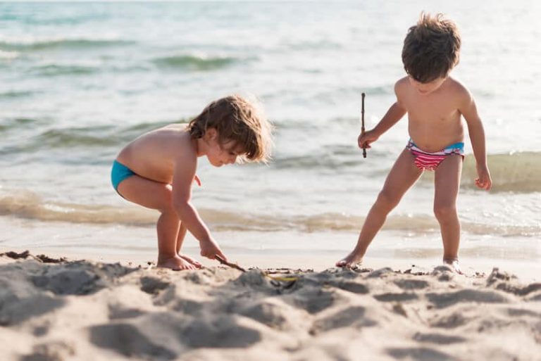 Deux enfants jouent sur la plage.