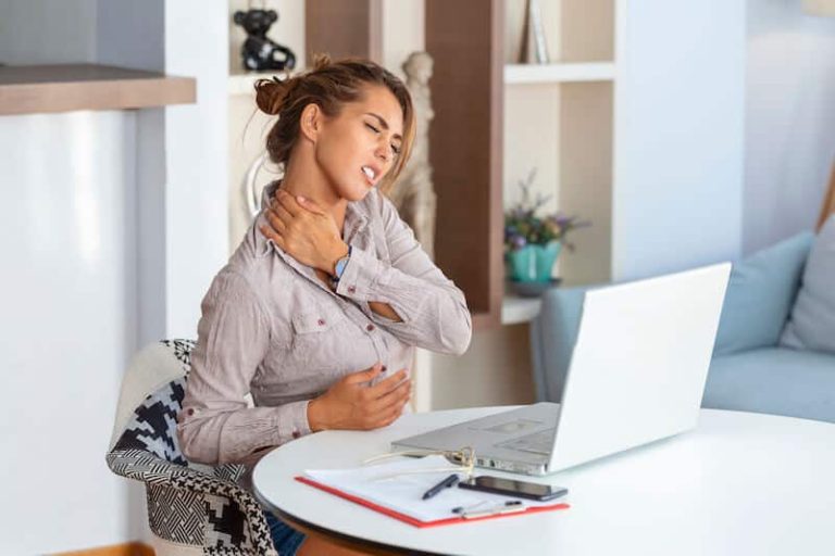 Une jeune femme en télétravail se plaint d'avoir mal au dos, l'un des principaux TMS.