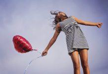 Les hormones du bonheur : fille qui vole avec un ballon en forme de coeur.
