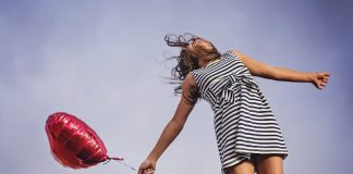Les hormones du bonheur : fille qui vole avec un ballon en forme de coeur.