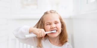 Une petite fille soucieuse d'avoir de belles dents suit les conseils en matière d'hygiène bucco-dentaire.