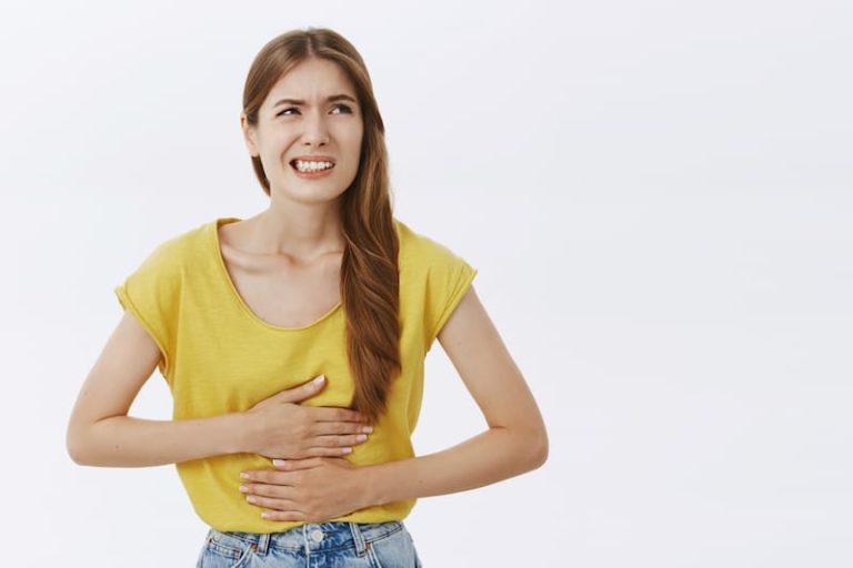 Une jeune femme atteinte de constipation et soucieux de trouver les aliments à privilégier pour y remédier.
