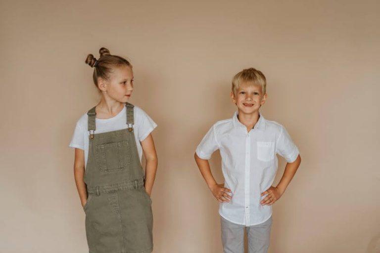 Deux enfants, une fille et un garçon, sont adossés contre un mur afin de comparer leur taille, sans révéler un quelconque trouble de la croissance.