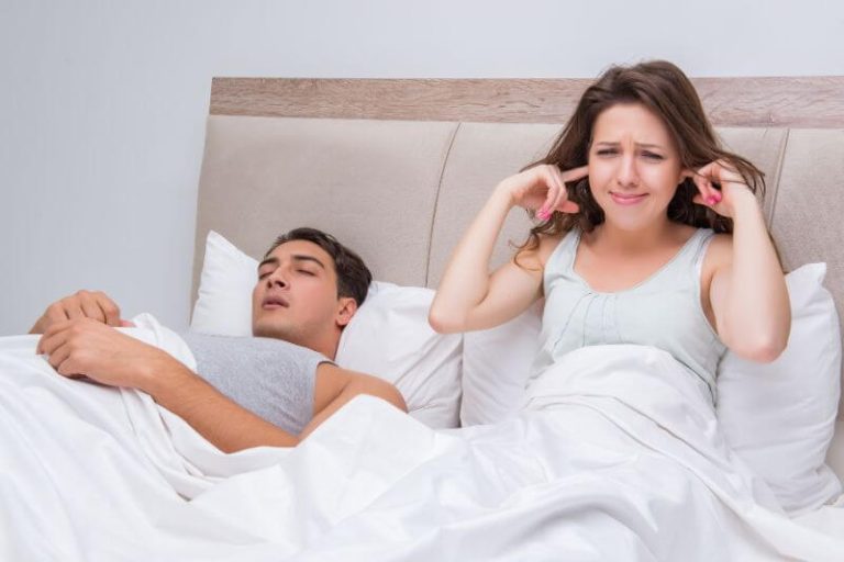 femme qui n'arrive pas à dormir à cause de son conjoint qui ronfle