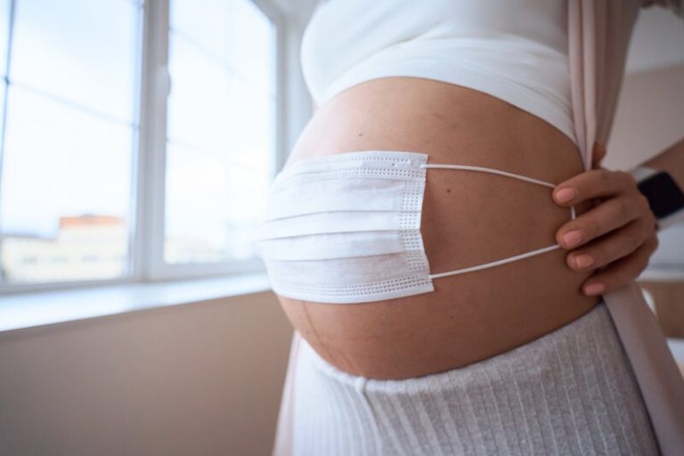 Une femme enceinte qui place un masque contre son ventre pour protéger son foetus de la pollution atmosphérique.