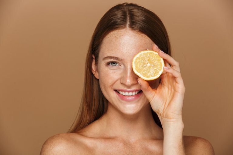 Une femme souriante avec un citron à la main.