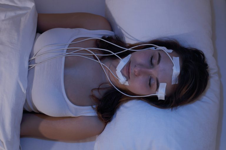 Une femme qui dort tout en passant une polysomnographie.