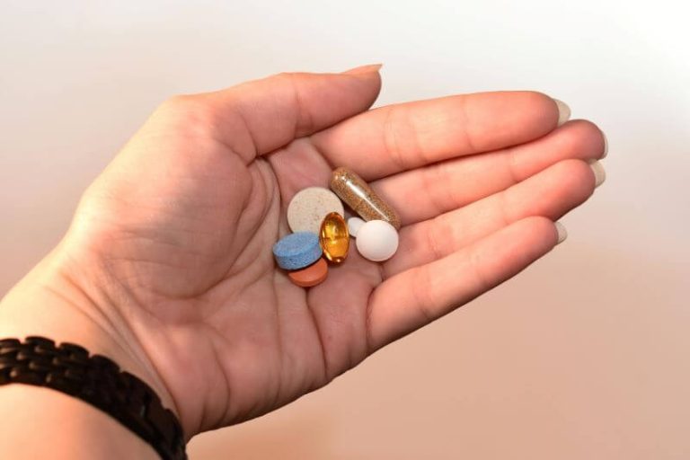 La main d'une femme tenant des médicaments