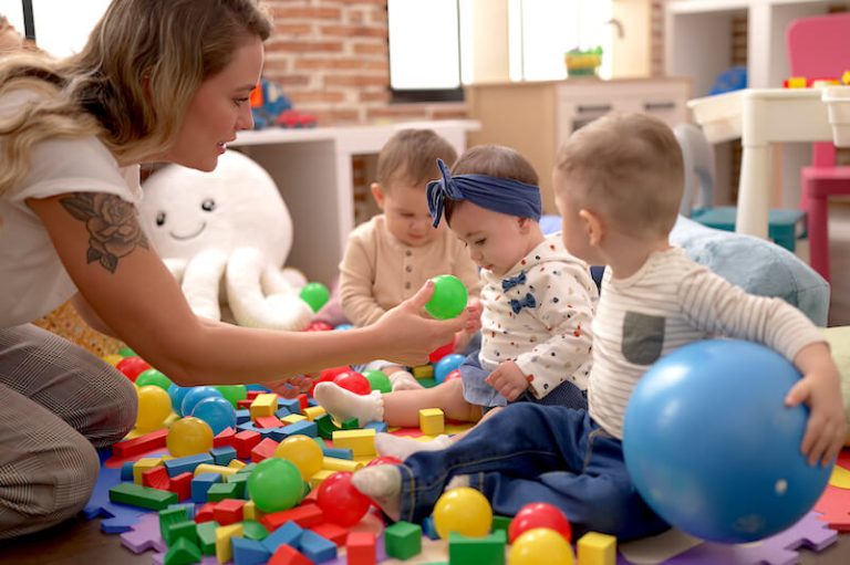 Une jeune éducatrice s'occupe d'enfants à la crèche, lieu de bientraitance.