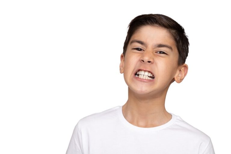 Un enfant qui grince des dents à cause du bruxisme.