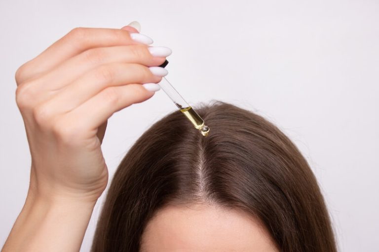 Une femme qui utilise les bienfait de l'huile de jojoba pour ses cheveux.
