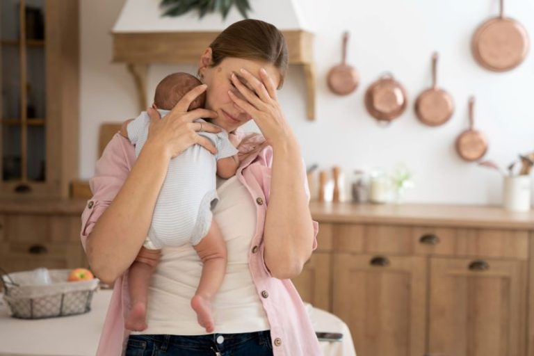 Une mère exténuée tient son enfant dans les bras.