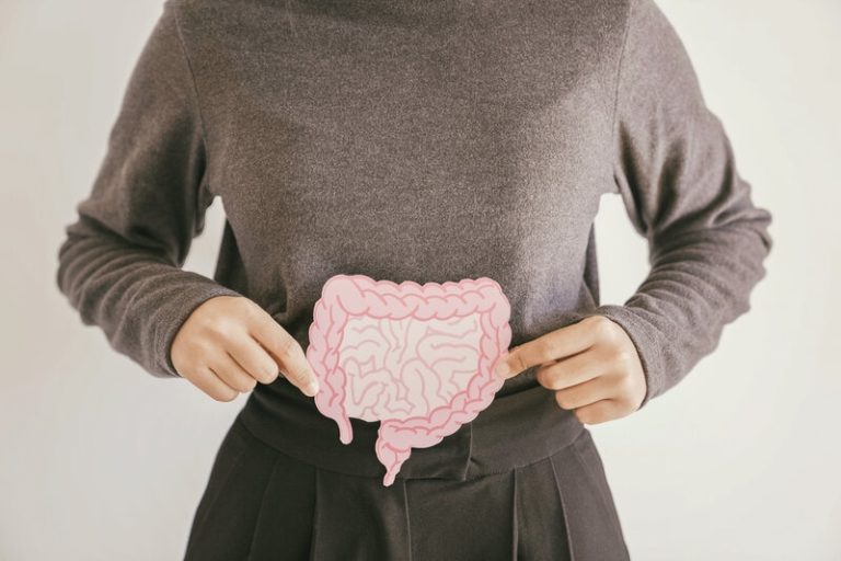 Une femme qui montre une flore intestinale en bonne santé grâce aux bienfaits des probiotiques.