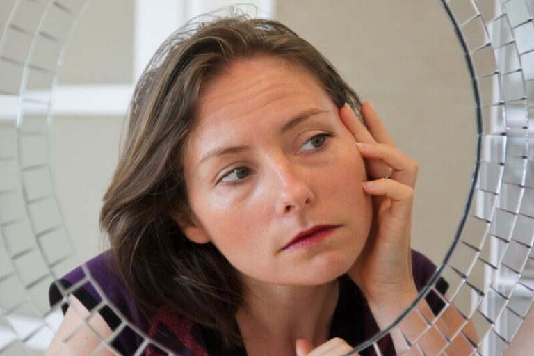 Une femme qui observe que sa peau vieillit plus vite à cause de sa consommation de sucre.
