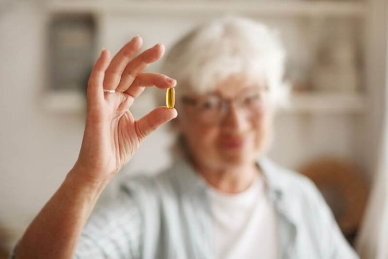Une dame âgée tient un complément de collagène.