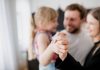 Syndrome du parent hélicoptère : quand la surprotection nuit à votre enfant Deux parents sourient en tenant la main de leur jeune fille.