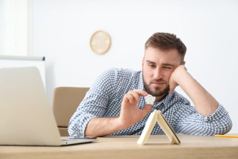 Un homme en train de procrastiner sur son lieu de travail.