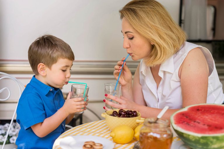 Une maman donne de l'eau à son enfant pendant le repas.