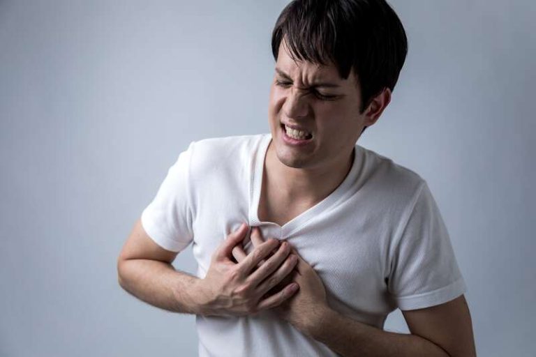 Un homme qui se tient la poitrine à cause d'une douleur intercostale.