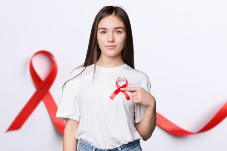 Une jeune femme brandit un ruban rouge, symbole de la lutte contre le sida.
