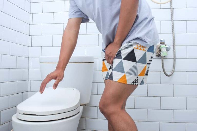 Un homme devant les toilettes la nuit avec une envie pressante.