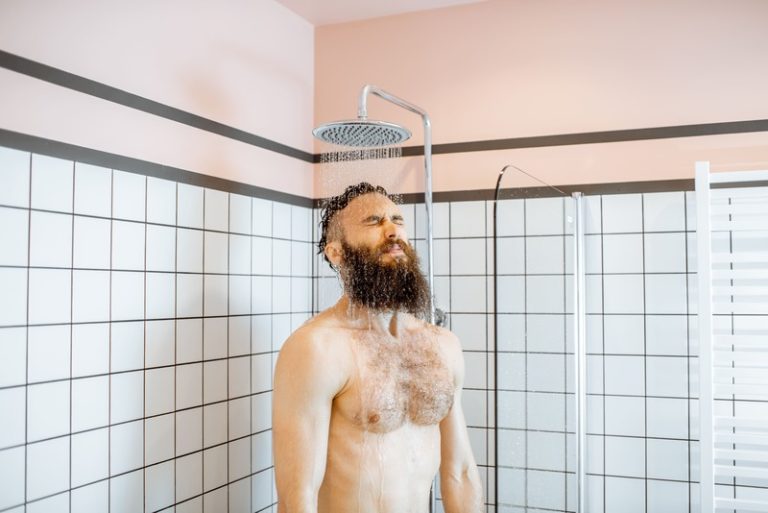 Un homme en train de prendre une douche froide pour ses bienfaits.