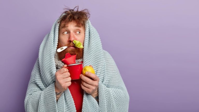 Un homme malade de la grippe qui mange se nourrit d'aliments anti-grippe.