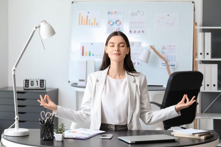 Jeune femme bien au travail devant son bureau.