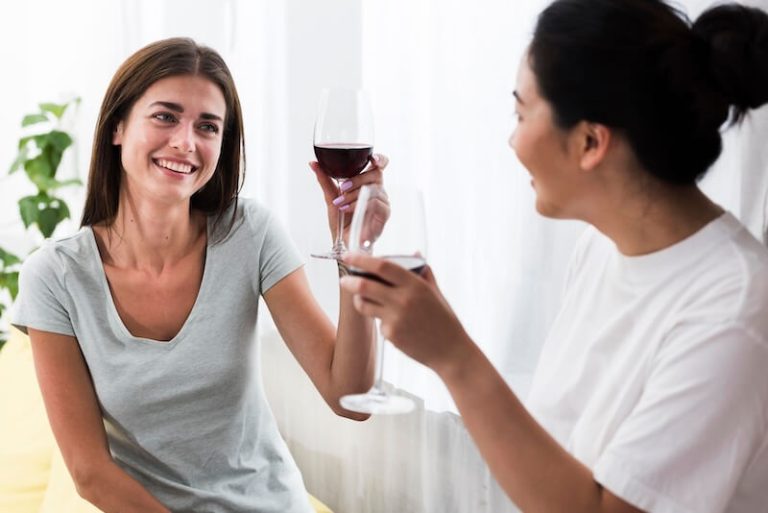 Deux jeunes femmes buvant du vin.