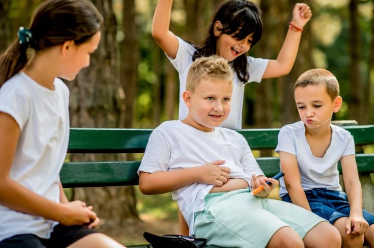 Un écolier diabétique testant sa glycémie après une éducation physique, des amis le soutiennent.