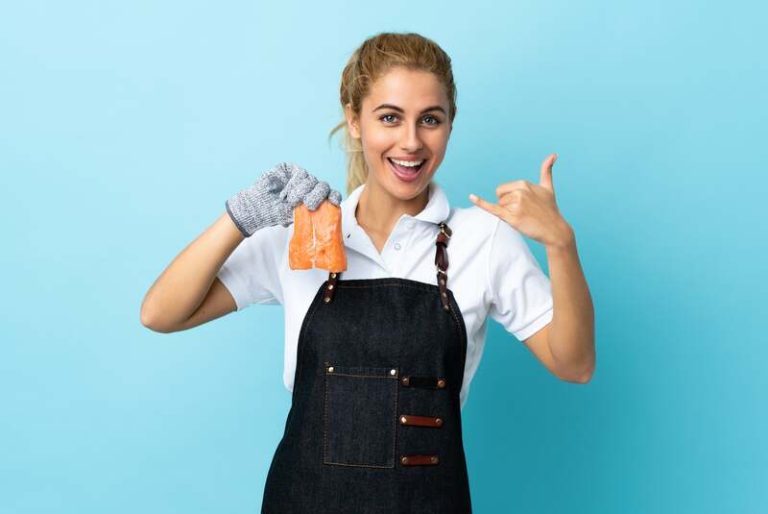 Une femme qui prépare du saumon pour le menu des fêtes de fin d'année.
