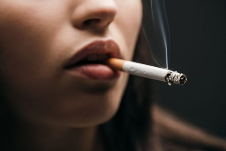 Une femme fume une cigarette.