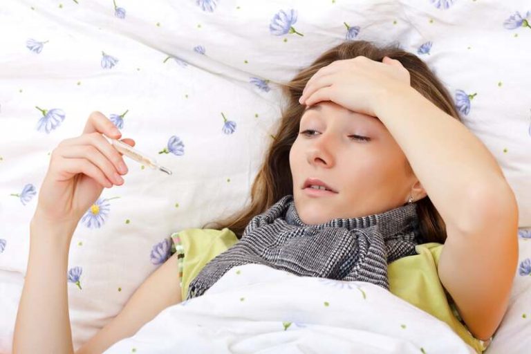 Une femme ayant attraper ce fameux "coup de froid", alors que c'est un virus, complètement malade au fond du lit.